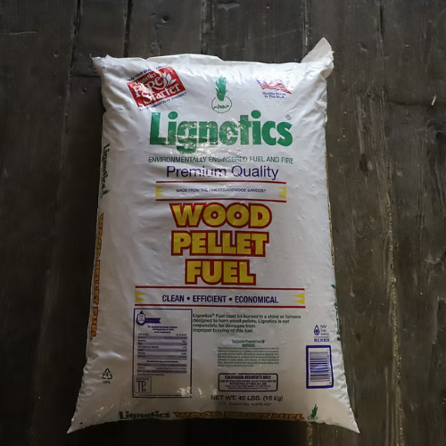 Bag of Lignetics Wood Pellet Fuel on a wooden floor. The bag is white with green and red text, promoting it as 